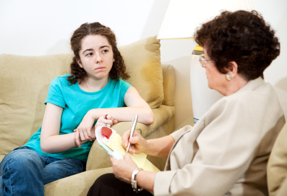 Depressed teen girl consulting with a psychologist.